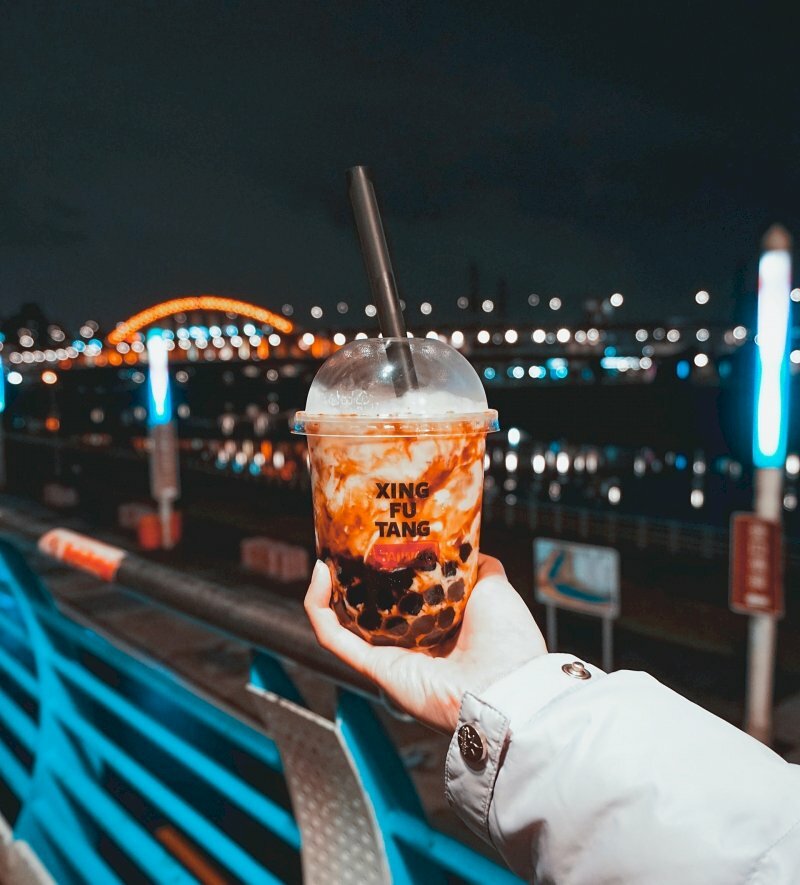 Hình ảnh tay cầm ly trà ѕữa tự chụp bên ѕông